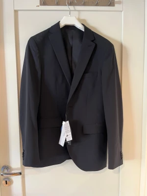 Mörkblå kavaj från matinique - Helt oanvänd mörkblå/oxford blå kavaj. Lappen sitter kvar. Nypris 2900, köpt på outlet. Perfekt för en dressad look eller avslutning/student/bal.