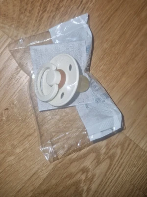 Napp - Napp från BIBS i färgen Ivory, tillverkad i latex. Klassisk rund form med ventilationshål och ring, perfekt för små barn. Kommer i originalförpackning och är enkel att ta med sig. Stilren och tidlös design.