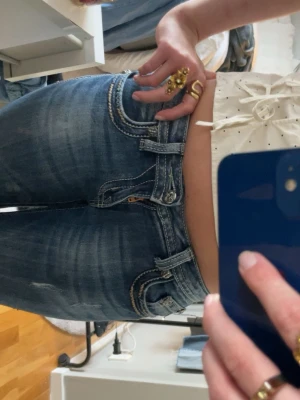 Miss me jeans - Säljer ett par mörkblå bootcut jeans från Miss me med snygga kontrastsömmar och detaljerade bakfickor med lock och metallknappar. Jeansen har låg midja och klassisk femficksdesign. Perfekta för dig som gillar en cool och tidlös look. Dem har några små defekter men inget som man tänker på när dem används ( kontakta för bättre bilder) 