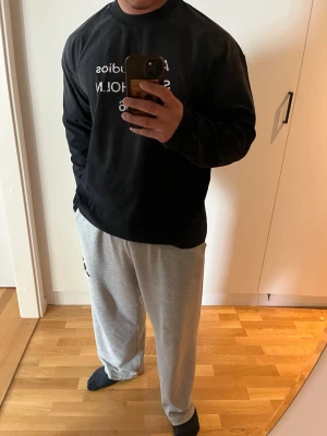 Svart långärmad  Acne Studios - Svart långärmad topp från Acne Studios med tryck 'STOCKHOLM 1996' i vitt framtill. Klassisk rund halsringning och relaxed fit. Perfekt för dig som gillar minimalistisk och stilren design.