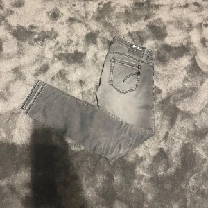 Dondup jeans gråa - Snygga grå dondup jeans med en slim passform. Skick runt 6/10. Lagade i skrevet men syns inte utifrån. Säljer så billigt pga av skicket, defekter förekommer. Fortfarande riktigt snygga dock