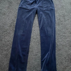 Blå juicy byxor - Intressekoll på mina blå juicy byxor! Kan tänka mig sälja för runt 400, i mycket fint skick förutom att en metall sak har ramlat av ( se bild 3 ) och därav priset!