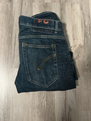 Dondup jeans, skinny fit.  - Snygga mörkblå jeans med raka ben och tydliga kontrastsömmar. Klassisk femficksmodell med detaljerad bakficka och diskret sliten look. Perfekta för en avslappnad stil. Materialet är denim i bomull.
