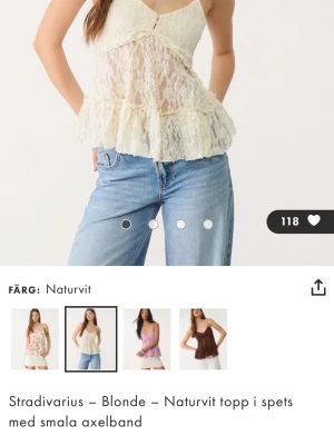 Naturvit spetslinne från Stradivarius - Söt naturvit linnetopp i spets från Stradivarius med smala axelband och volang nertill. Toppen är ärmlös och har en romantisk känsla med transparent spets och liten rosett framtill. Perfekt för en trendig och feminin look.