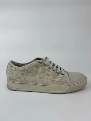 Beige Lanvin sneakers med textur - Snygga beige sneakers med texturerad ovandel och matchande beige snörning. Skorna har en låg profil och rund tå, samt en slät sula i gummi. Perfekta för dig som gillar stilrena och minimalistiska sneakers med en twist.