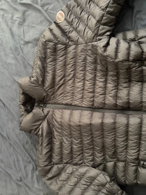 Svarr dunjacka från Colmar - Snygg svart dunjacka från Colmar med quiltad design och dragkedja framtill. Jackan har en hög krage och ett klassiskt Colmar-märke på ärmen. Perfekt för kalla vinterdagar och riktigt skön att bära. Funkar också bra till sena sommar kvällar