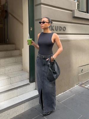 Svart maxikjol i denim från Nelly - Trendig svart maxikjol i denim från Nelly. Kjolen har en rak passform och stängs med knapp och dragkedja. Perfekt för en cool och avslappnad look 🤍 