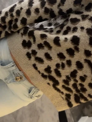  leopardmönstrad stickad tröja - Säljer en  stickad tröja med svart leopardmönster. Tröjan har rund halsringning och ribbade muddar vid ärmslut och nederkant. Perfekt för dig som vill ha en trendig och mysig look 🐆🐆🐆🐆