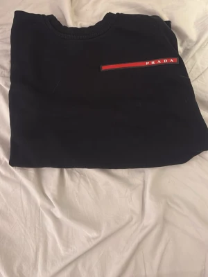Svart Prada tröja  - Snygg svart tröja, använd 1 gång. Passar mig jättebra som är 176cm lång och väldigt skön tröja