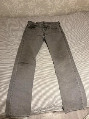 Ljus grå 501 Levis  - Ljusgråa Levis jeans 501. Snygga men sitter inte bra på mig. Bra skick inga synliga defekter. Storlek 32/34 