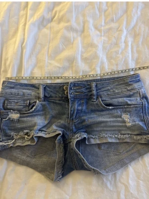 Blå jeansshorts  - Säljer dessa skitsnygga jeansshorts med slitningar. Mycket bra skick, perfekta till sommaren. Storlek 32 men passar även XS