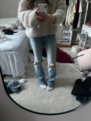 Ljusblå jeans med hål Från nelly - Säljer ett par ljusblå jeans med hål vid knäna. På den sista bilden så har den slitits av så det är ett håll under med det syns ej när man har på sig dom, därav priset💗