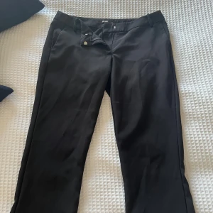 Svarta kostymbyxor från BikBok - Snygga svarta kostymbyxor i den populära modellen ”Vera” från BikBok i storlek 38. Byxorna har hällor för skärp, två sidofickor och stängs med knapp och dragkedja. Perfekta för en clean och stilren look. Materialet känns mjukt och har en lätt stretch. Bra längd på mig som är 168cm. 💛Köpta för ungefär 1 år sedan men är inte använda speciellt mycket då dem inte sitter som jag önskat. Köpta för 500kr. Kan gå med på prisförslag vid snabb affär!!💛