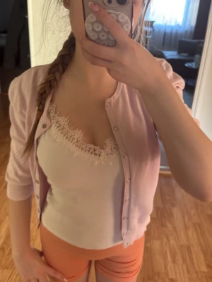 Ljusrosa kofta med knappar - Söt ljusrosa kofta med långa ärmar och ribbade muddar. Koftan har en klassisk rak passform och knäpps framtill med små silverfärgade knappar. Perfekt att slänga över en topp för en chill look.