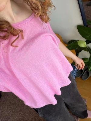 Ljusrosa offshoulder topp - Säljer en ljusrosa topp med offshoulder-design och lös passform. Toppen är tunn och luftig, perfekt för varmare dagar. Materialet känns mjukt och bekvämt mot huden. Enkel och stilren modell som är lätt att matcha.