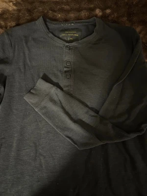 Tröja  - En tröja med knappar till killar , super fint till chinos eller jeans , lite nopprig på insidan där runt lappen å lite på men de syns knappt i verkligheten 