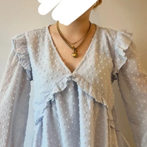 Ljusblå volangblus från Gina Tricot. - Supersöt ljusblå blus med volangdetaljer och diskret prickigt mönster. Strl 170. 