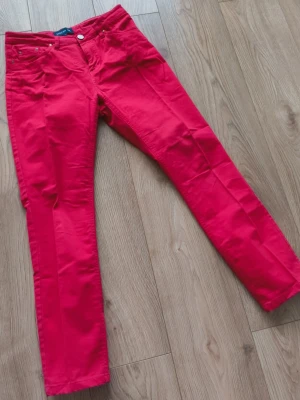 Röda 3/4 byxor från STOCKH LM - Snygga röda 3/4 byxor från STOCKH LM i storlek 36. Byxorna har smal passform, klassisk femficksdesign och är tillverkade i ett mjukt bomullsmaterial med lite stretch. Perfekta för dig som vill sticka ut med färg i din outfit.