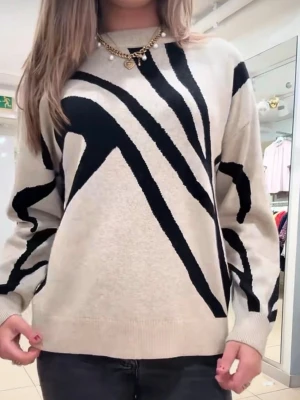 Beige stickad tröja med svart mönster - Snygg beige stickad tröja med svart abstrakt mönster över hela plagget. Tröjan har rund halsringning, långa ärmar och ribbade muddar vid ärmslut och nederkant. Perfekt för dig som gillar en trendig och unik look. Helt ny endast provad, nypris 499kr, priset kan diskuteras. 
