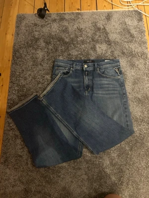 Blå raka jeans från replay  - Säljer ett par klassiska blå jeans från replay.  Jeans med rak passform och fem fickor. Jeansen har en snygg tvättad look och detaljerade sömmar på bakfickorna. Tillverkade i bomull med en tidlös design som passar till det mesta. Storlek 158/164