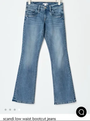 Blå bootcut jeans låg midja - Snygga blå bootcut jeans med låg midja och klassisk femficksdesign. Jeansen har en lätt tvättad look och utsvängda ben, perfekta för en avslappnad och trendig stil. Tillverkade i denim med skön stretch.