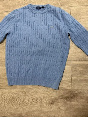 2x GANT Kabelstickade Tröjor – Blå & Marin – Strl S - Säljer två kabelstickade tröjor från GANT i blå och marinblå. Storlek S, fint skick utan hål eller fläckar. Klassisk modell med broderad GANT-logga på bröstet. Perfekta till både vardag och mer uppklätt – funkar lika bra med jeans som över skjorta. Säljs separat eller tillsammans.