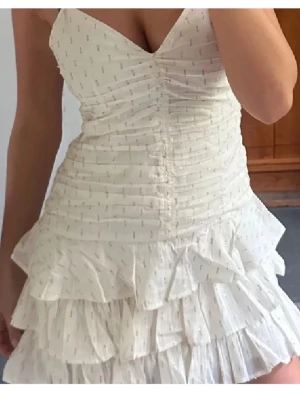 Volangklänning H&M - Superfin klänning för alla tillfällen! Oanvänd💘Perfekt till sommaren och fest. Vit med guldiga detaljer samt volang nertill.