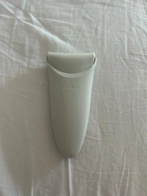 Grå rakhyvelhållare från Estrid - Minimalistisk rakhyvelhållare i ljusgrått från Estrid. Tillverkad i plast med en stilren, mjukt rundad form och Estrid-loggan på framsidan. Perfekt för att förvara din rakhyvel på ett snyggt och praktiskt sätt i badrummet.