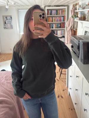Mörkgrön oversized sweatshirt - En enkel och stilren mörkgrön sweatshirt med avslappnad passform och rund hals. Tröjan har långa ärmar och ribbade muddar vid ärmslut och nederkant. Perfekt för en chill och casual look till vardags.