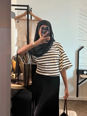 Randig åtsittande topp med vida ärmar - Snygg topp med svartvita ränder och vida, korta ärmar. Toppen har en lös passform och är perfekt för dig som gillar en avslappnad men trendig stil. 