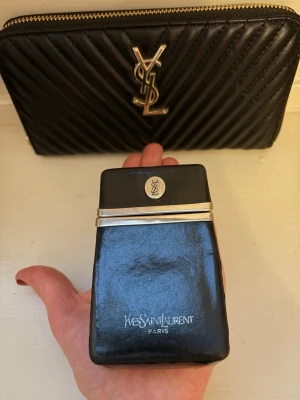 YSL svart äkta mkt sällsynt cigarettetui vintage läder - Sällsynt och eftertraktat vintage cigarettetui från YSL, 1970/80-tal. Kan användas för att bära kreditkort, kontanter, smink, smycken, nycklar, andra småsaker. Perfekt för dig som vill ha en unik designeraccessoar med exklusiv känsla.