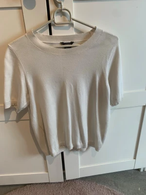 Vit kortärmad topp från Lindex - En stilren vit topp från Lindex i storlek XS. 