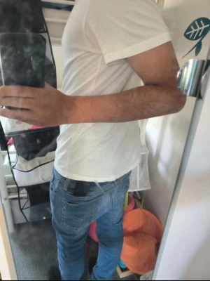 Blå slim fit jeans med fickdetalj - Säljer ett par blå slim fit jeans med klassisk femficksdesign och snygga sömmar på bakfickan. Jeansen har normal midja och är tillverkade i ett mjukt denimtyg som sitter skönt. Perfekta för en avslappnad och trendig look.