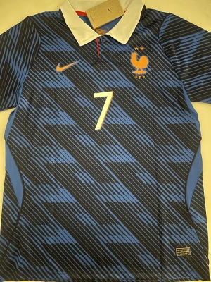 Ousmane Dembele Frankrike Vm 2026 tröja  - Fotbollströja i helt nytt och oanvänt skick med tag kvar. Detaljrik design och bekvämt material som passar både till match och vardag. Detta är en inofficiell version av modellen. Storlek M