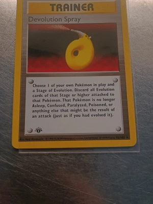 Devolution spray 1st Edition  - Säljer ett original Pokémonkort, Devolution Spray Trainer från Base Set. Kortet har gul ram, klassisk design och tydlig text. Perfekt för samlare eller dig som vill komplettera din kortlek. Kortet är tryckt på tjockt papper med färgstark framsida och blå baksida.