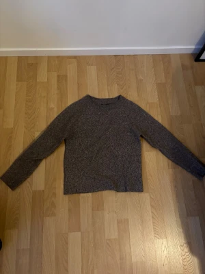 Brunmelerad stickad tröja Vero Moda - Mysig brunmelerad stickad tröja från Vero Moda. Tröjan har rund halsringning, lång ärm och rak passform. Perfekt för lager på lager och enkel att matcha med jeans eller kjol. Materialet är mjukt och bekvämt för kalla dagar.