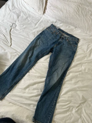 Levi's 541 blå raka jeans - Säljer ett par klassiska blå Levi's 541 jeans med rak passform. Jeansen har en snygg tvättad look och är gjorda i slitstarkt denim. Perfekta för dig som gillar en tidlös och grich laidback stil. Använda men mycket väl skötta! Liten fläck på ena benet som man behöver en tubkikare för att se, inte många som går runt med det nu förtiden så inget att oroa sig för :)