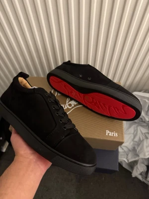 Svarta Loubs sneakers med röd sula - Säljer ett par helt nya svarta Loubs med röd sula. Storlek 43. Skriv vid minsta intresse! 