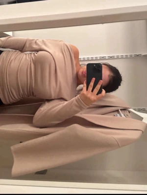 Beige offshoulder topp - Trendig beige offshoulder topp med lång ärm och tight passform. Tunn och mjuk känsla, perfekt för att styla med jeans eller kjol. Enkel men elegant design som ger en clean look.