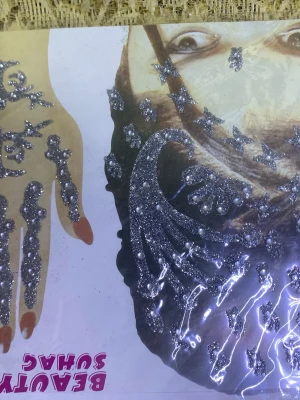 Glittriga ansikts- och hårdekaler - Säljer ett ark med glittriga silverfärgade dekaler för ansikte och hår. Perfekt för att skapa unika looks till festival eller party. Dekalerna har olika former som stjärnor, blommor och vågor och fästs enkelt på huden eller i håret. Finns fler kvar 