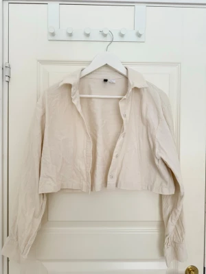 Vit kofta med knappar - Vit kofta med knappar som är enkel och passande inför sommaren. En lätt jacka