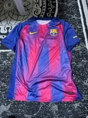 FC Barcelona matchtröja Nike utan Spotify loggan - Säljer en officiell FC Barcelona matchtröja från Nike med klassiska blå och röda vertikala ränder. Tröjan har klubbmärket på bröstet, gul Nike-logga och är tillverkad i lätt, ventilerande material med Dri-FIT-teknologi. Perfekt för fotbollsträning eller att bära på läktaren.