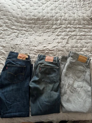 Jeans x3 - Säljer dessa jeans i paket av 3. Två stycken Levis och en från Jack & Jones. Samtliga byxor är använda men inga synliga skador. Byxorna i mitten och till höger i första bilden är inte lika ”baggy” som de till vänster. Men samtliga är ca 32 & 32 i storlek. Bilder inlagda så ni kan se hur de ungefär sitter på mig som är 184 cm. Skriv för fler bilder eller funderingar
