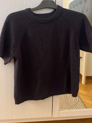 Mörkblå stickad tröja från 157 - Mörkblå stickad tröja från 157 med korta ärmar och rund halsringning. Passar mig som har storlek XS/S ser nopprigare ut på bilden en vad den är i verkligheten 