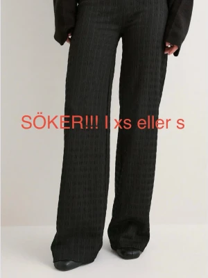 Svarta vida byxor med struktur - Söker dessa svarta lågmidjade byxor från Nelly i antingen storlek xs eller s!!