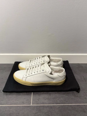 Saint Laurent 06  - Saint Laurent 06 vit, storlek 38,5 passar 39,5, skick 8/10, 2 dustbags medföljer vid köp, vid funderingar hör av er. 