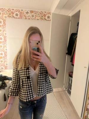 Svartvit kavaj med hundtandsmönster - Säljer en snygg svartvit kappa med klassiskt hundtandsmönster som är trekvartärmad. Den är så fin och helt perfekt nu till våren och sommaren! Säljer den då den är lite liten för mig men passar perfekt på en xxs skulle jag säga❣️