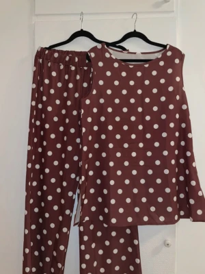 Prickigt set (kan säljas var för sig)  - Supergulligt prickigt sett med topp och byxa i brunt och vitt. Kan säljas var del för sig om det är intressant! Byxorna är vida och går till marken på mig som är ca160 lång.   Kom gärna med bud!✨