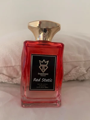 Bujarami Red Static parfym 100ml - Säljer en snygg parfymflaska från Bujarami Sydney, modellen Red Static. Flaskan är röd med guldigt lock och har en modern, kantig design. Innehåller 100 ml eau de parfum. Perfekt för dig som gillar unika och stilrena dofter.