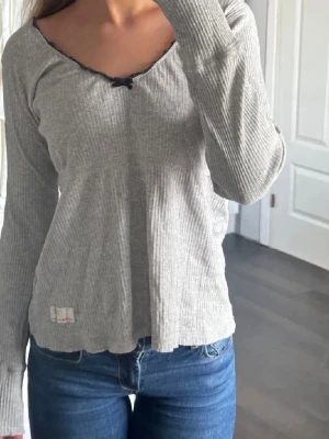oddmolly Grå ribbad långärmad topp - Säljer min älskade grå oddmolly tröja.💓Som har en fågel på armen och rosett vid halsen. 💘💘passar storlekarna S-L🫶🏼 Skriv för fler bilder så löser jag det!